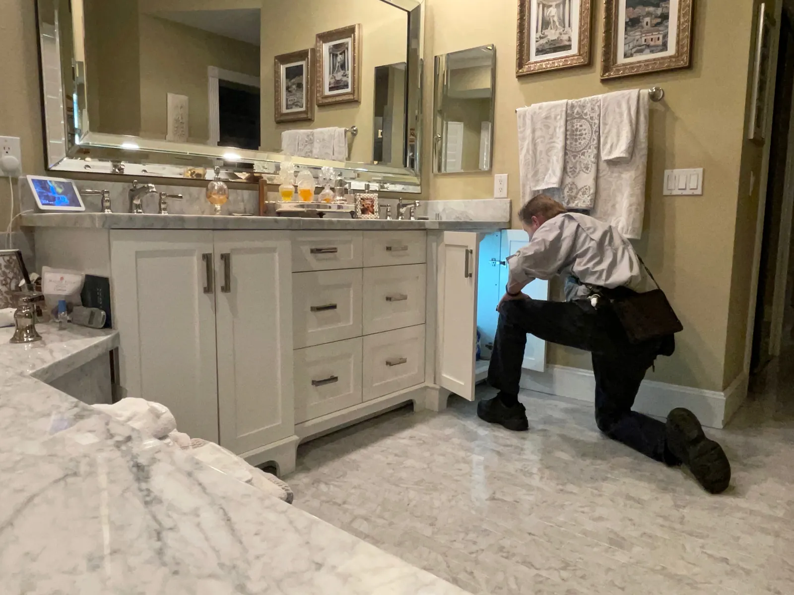 Rob Kruger checking plumbing under a bathroom vanity