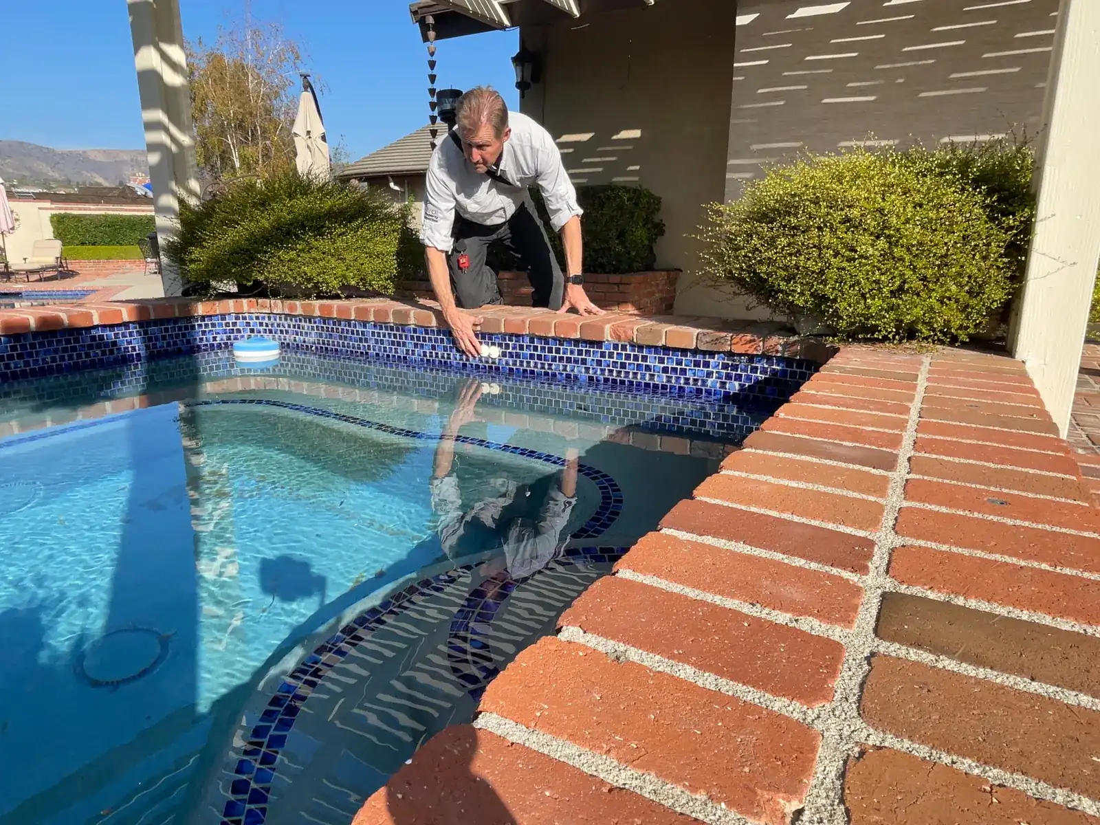 Rob Kruger taking a water sample from a pool during an inspection